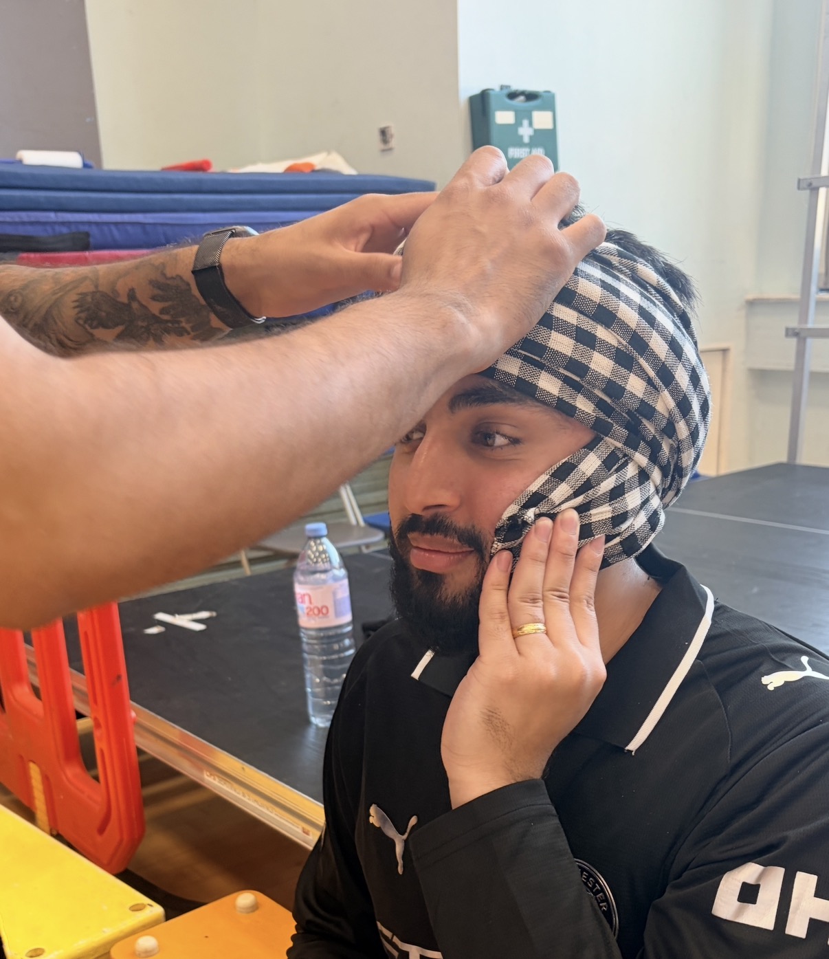 A performer having his turban prepared behind the scenes