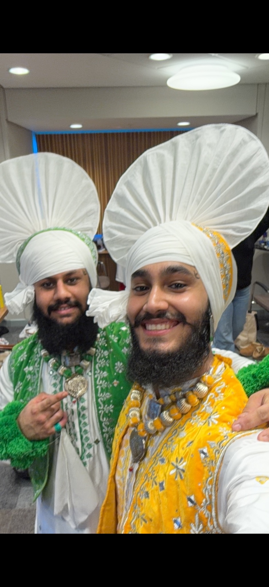Two LU Bhangra dancers taking a backstage selfie in traditional costumes