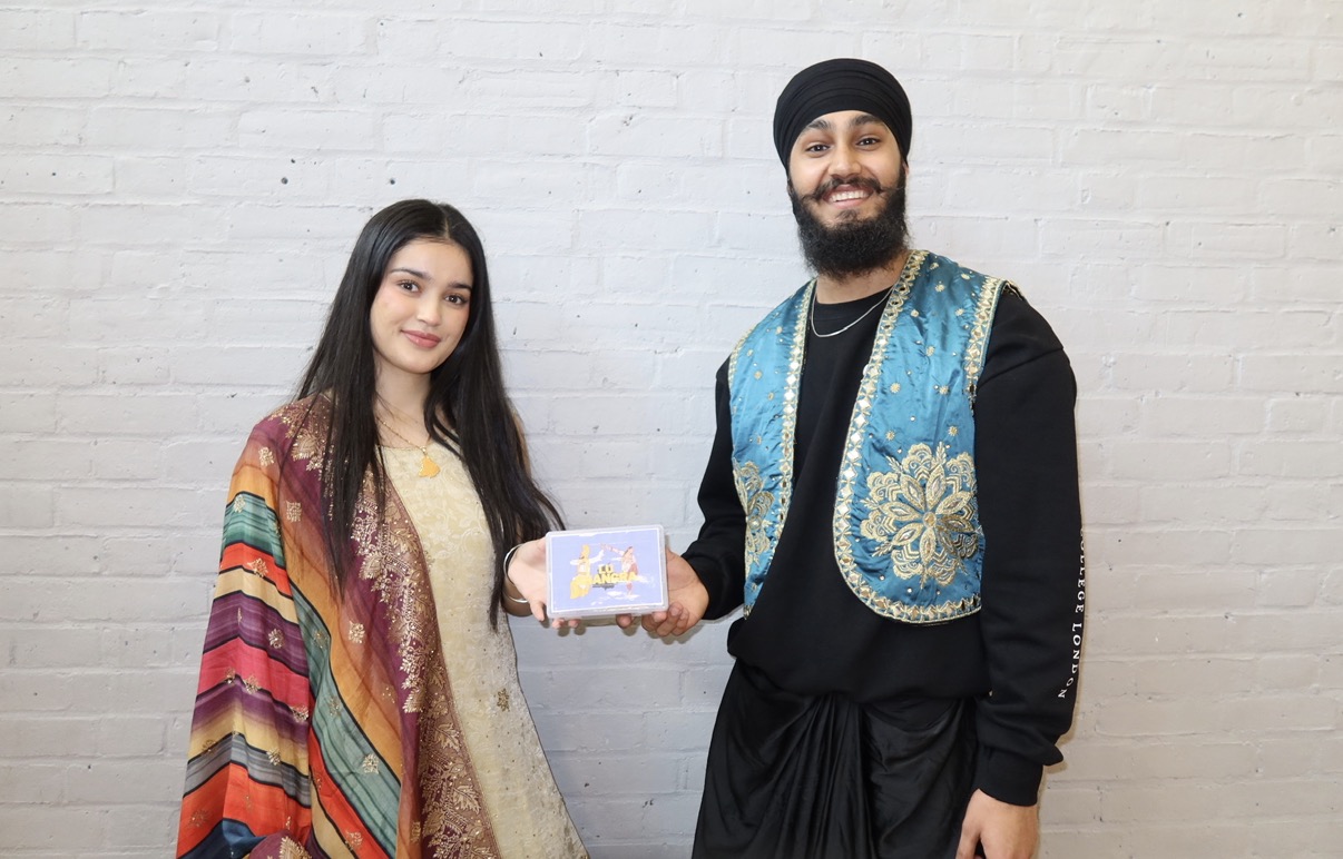 An LU Bhangra performer presenting a small event memento to a guest